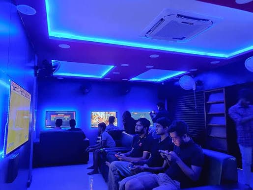 Players inside PS4 Gaming Lounge under blue lighting